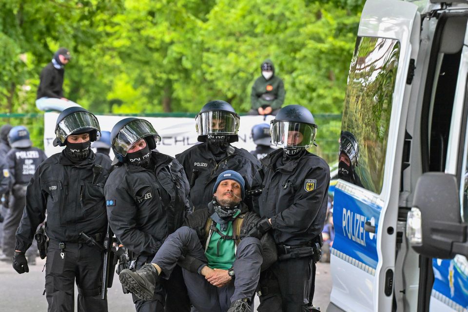 Police carry an activist from a blockade at the access road to Neuhardenberg airfield in Germany (Patrick Pleul/dpa via AP)