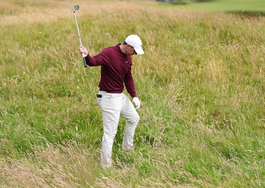 Rory McIlroy looks down at the rough after only moving his ball a few yards on the fourth hole (Zac Goodwin/PA)