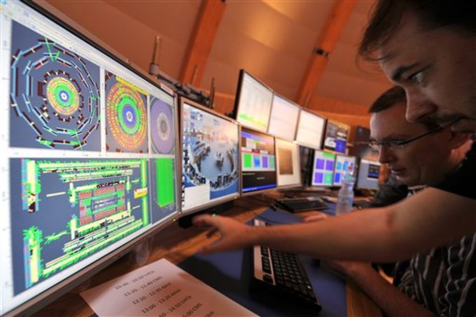 European Center for Nuclear Research (CERN) scientists control computer screens showing traces on Atlas experiment of the first protons injected in the Large Hadron Collider (LHC) during its switch on operation at the Cern's press center on Wednesday, Sept. 10, 2008 near Geneva, Switzerland. Scientists fired a first beam of protons around a 27-kilometer (17mile) tunnel housing the Large Hadron Collider (LHC). They hope to recreate conditions just after the so-called Big Bang. The international group of scientists plan to smash particles together to create, on a small-scale, re-enactments of the Big Bang. (AP Photo/Fabrice Coffrini, Pool)