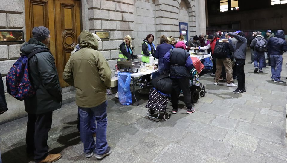 Families queue up at The Lending Hand, a soup kitchen feeding up 300 people every Monday evening on College Green in Dublin city centre (Niall Carson/PA)