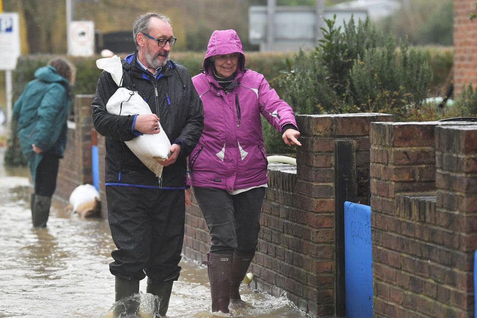 Residents picking up sandbags in Gloucester Road in Tewkesbury, Gloucestershire, where pumps and flood barriers have been put in to help to keep the water from flooding homes following the aftermath of Storm Dennis.