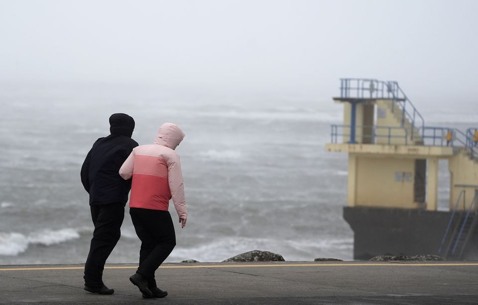 People struggle to walk in the wind on the promenade in Salthill, Galway on Sunday (Brian Lawless/PA).