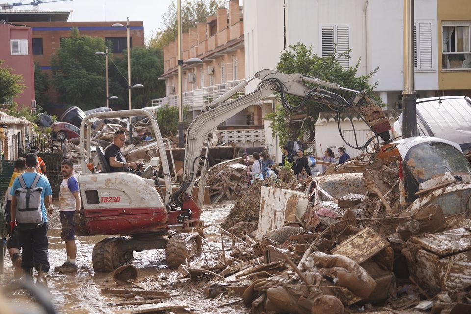 A small crane works to clear away debris during the clean-up in Massanassa, just outside of Valencia (Alberto Saiz/AP/PA)