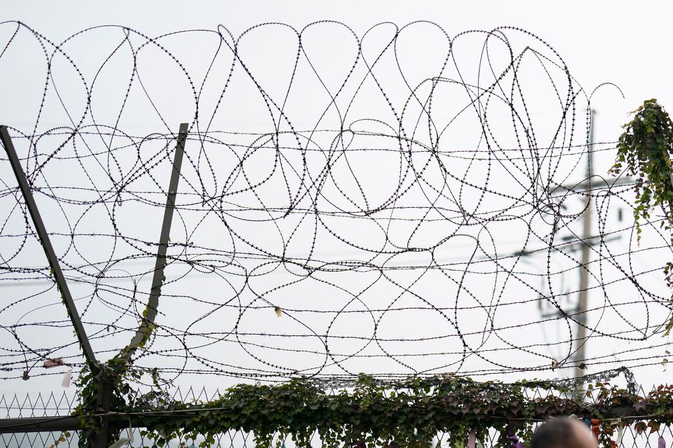 A visitor walks near a wire fence decorated with ribbons written with messages wishing for the reunification of the two Koreas at the Imjingak Pavilion in Paju, South Korea (Lee Jin-man/AP)