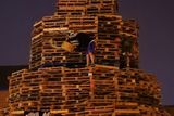 thumbnail: A man lights an 11th night Bonfire in the Sandy Row area of Belfast.  PRESS ASSOCIATION Photo. Picture date: Thursday July 12, 2018. Hundreds of bonfires were set to be lit at midnight as part of a loyalist tradition to mark the anniversary of the Protestant King William's victory over the Catholic King James at the Battle of the Boyne in 1690. See PA story ULSTER Bonfires. Photo credit should read: Niall Carson/PA Wire