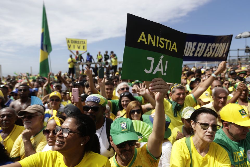 A supporter of former president Jair Bolsonaro holds up a sign that reads in Portuguese ‘Amnesty Now’, during the rally on Copacabana Beach (Bruna Prado/AP)