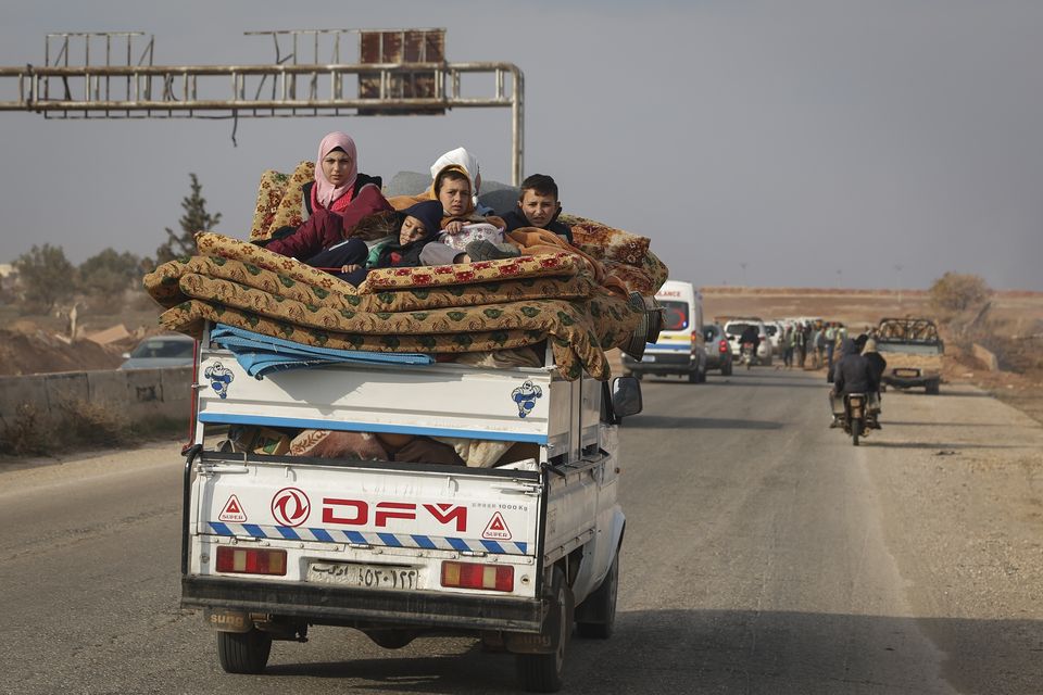 Residents flee the fighting in Hama carrying their belongings (AP Photo/Ghaith Alsayed)