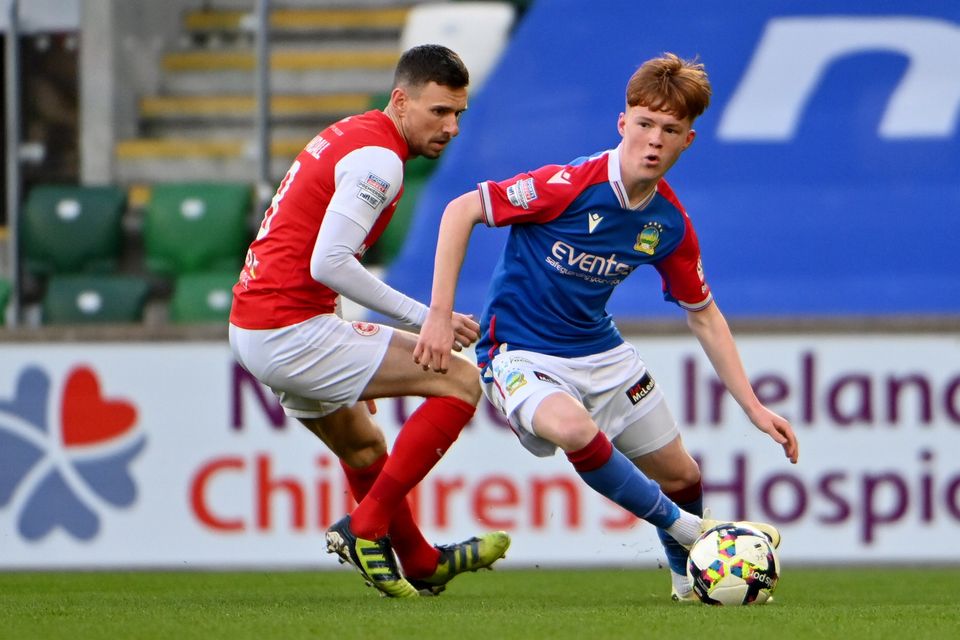 Linfield Academy talent Braiden Graham is tracked by Larne midfielder Mark Randall at Windsor Park