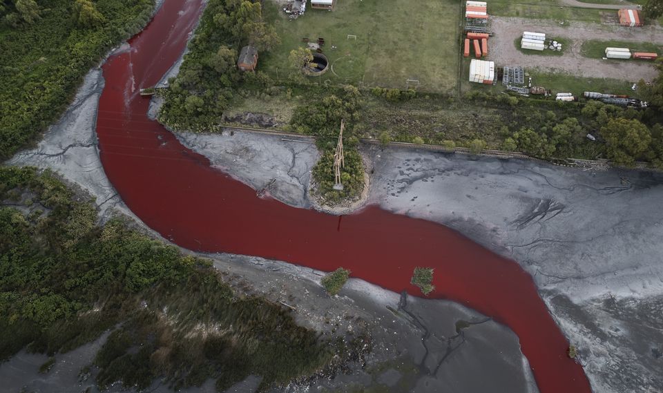 The waterway runs through an industrial neighbourhood on the outskirts of Buenos Aires (Rodrigo Abd/AP)