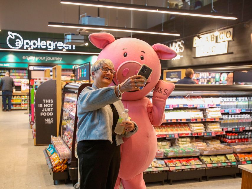 M&S mascot Percy Pig with a customer at the new M&S Food store at Lisburn South's Applegreen filling station