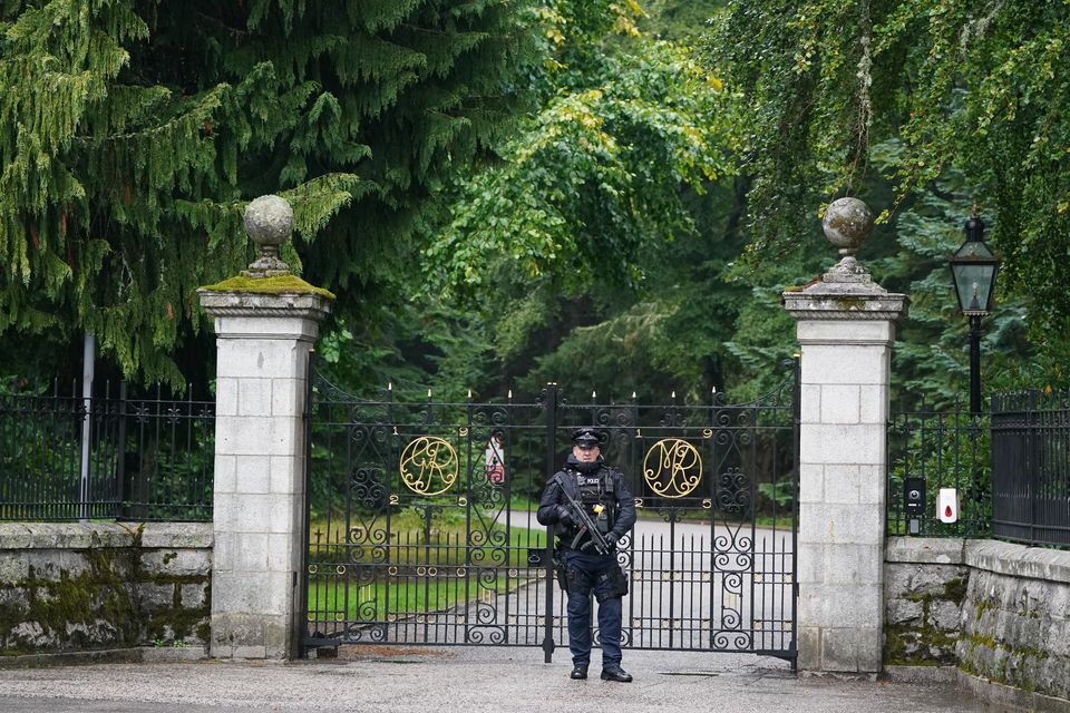 An armed police officer at the gates to Balmoral while the Queen was under medical supervision (Andrew Milligan/PA)