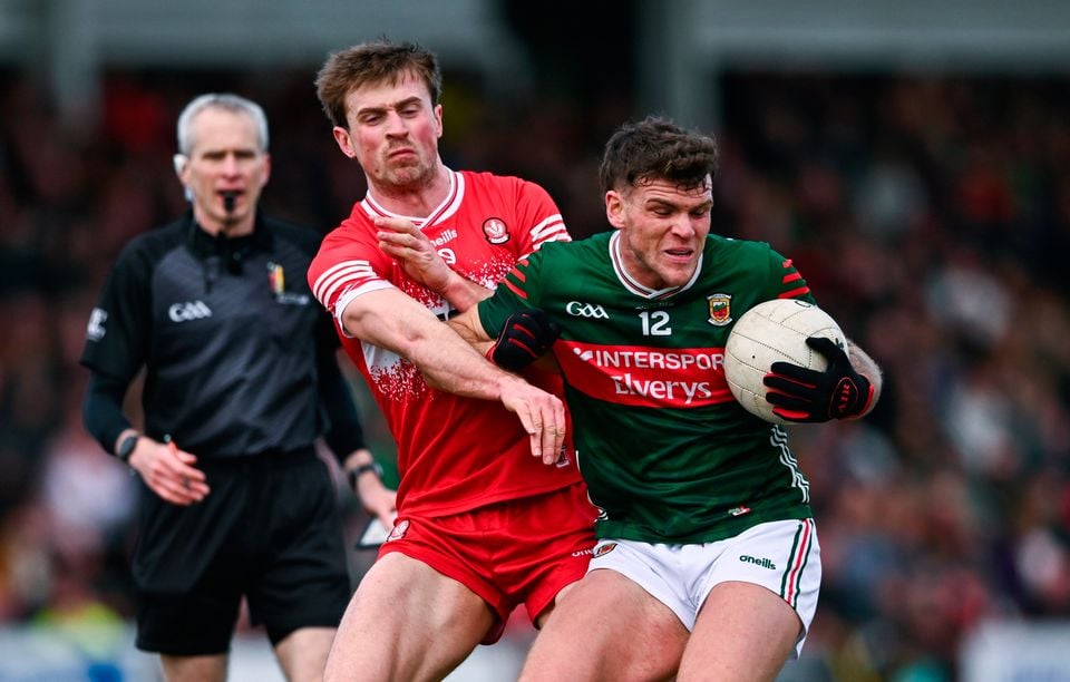 Derry's Anton Tohill looks to fend off the challenge of Mayo opponent Jordan Flynn