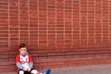 thumbnail: The beautiful game - football fans from around the world -  A young Southampton fan next to a brick memorial wall before the Premier League match at St Mary's, Southampton.