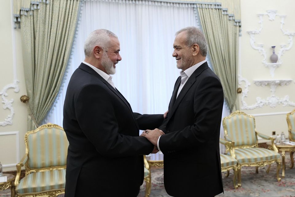 In this photo released by the Iranian Presidency Office, president Masoud Pezeshkian, right, shakes hands with Hamas chief Ismail Haniyeh (Iranian Presidency Office via AP)