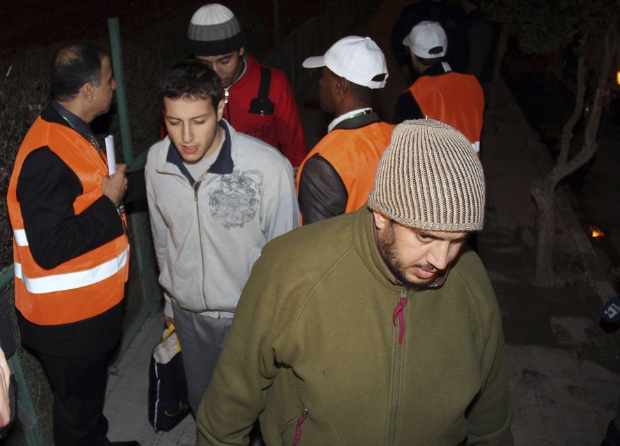 Arab League observers, with orange vests, oversee the releasing of Syrian prisoners as they leave Adra Prison in 2012 (AP)