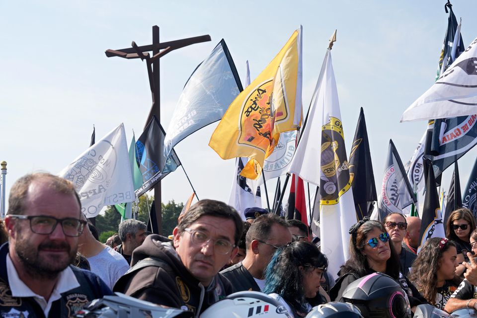 Motorcyclists holding their helmets and their groups’ banners gather at the Roman Catholic holy shrine of Fatima (Ana Brigida/AP)