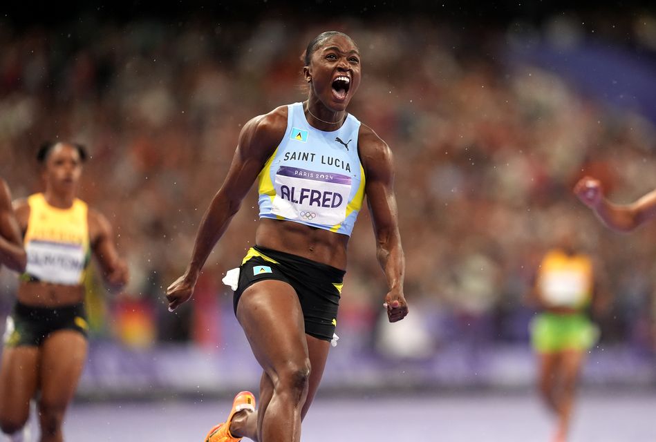 Julien Alfred celebrates winning the 100m final (Martin Rickett/PA)