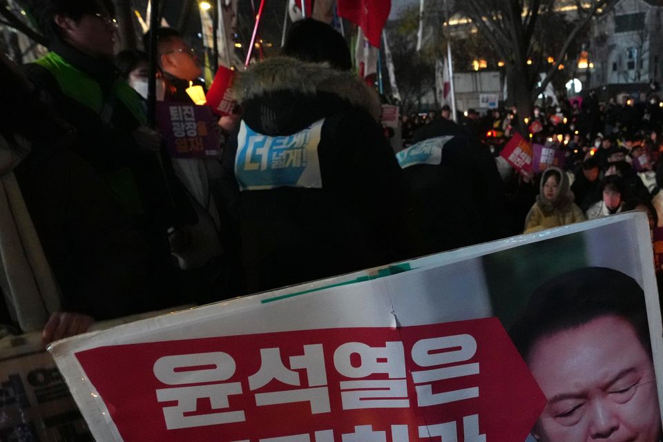 People hold candles during a candlelight vigil against South Korean President Yoon Suk Yeol in Seoul (Lee Jin-man/AP)