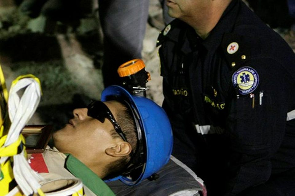Carlos Mamani, 23, is stretchered off as he becomes the fourth miner to exit the rescue capsule, on October 13, 2010 at the San Jose mine