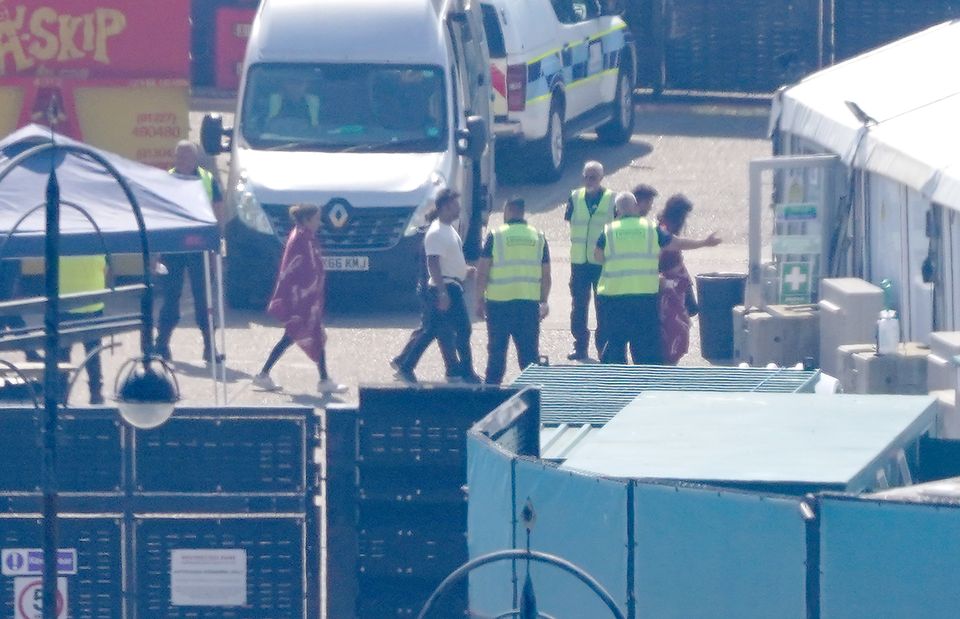 A group of people thought to be migrants are escorted away after arriving on a Border Force vessel in Dover (Gareth Fuller/PA)