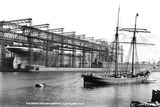 thumbnail: Titanic. The Great gantry, Queen's Island, Belfast. This photograph shows the enormous scale of the ship, together with the complex structure of the enfolding steel gantry, from which she will soon be free. The photograph also reflects old and new maritime technologies, with the traditional wooden schooner in the foreground contrasting eith the modernity ot Titanic. Photograph © National Museums Northern Ireland. Collection Harland & Wolff, Ulster Folk & Transport Museum