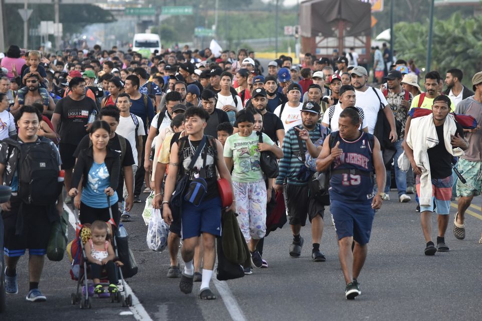 Migrants walk along the highway through Suchiate, Chiapas state (Edgar H Clemente/AP)