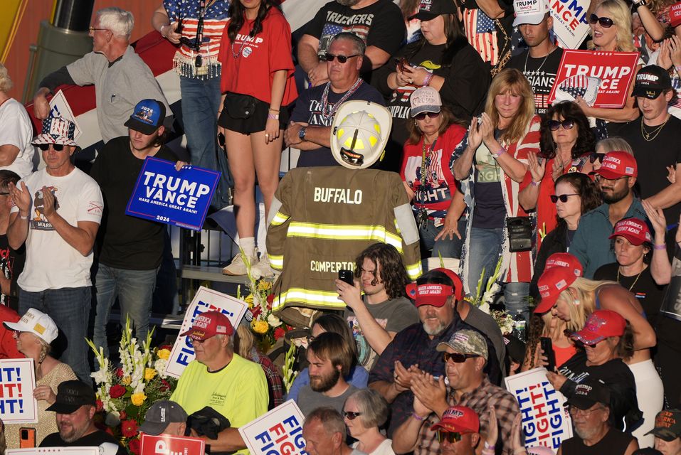 Attendees cheer as they stand near a memorial for firefighter Corey Comperatore (Alex Brandon/AP)