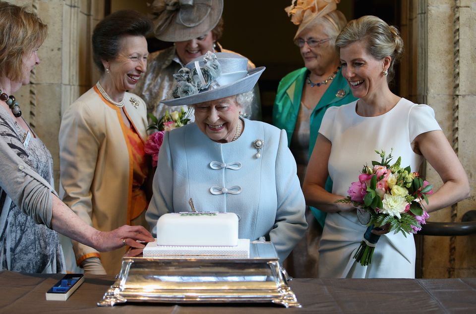 The then-Countess of Wessex and the Princess Royal look on as the Queen cuts a Women’s Institute 100th anniversary cake in 2015 (Chris Jackson/PA)