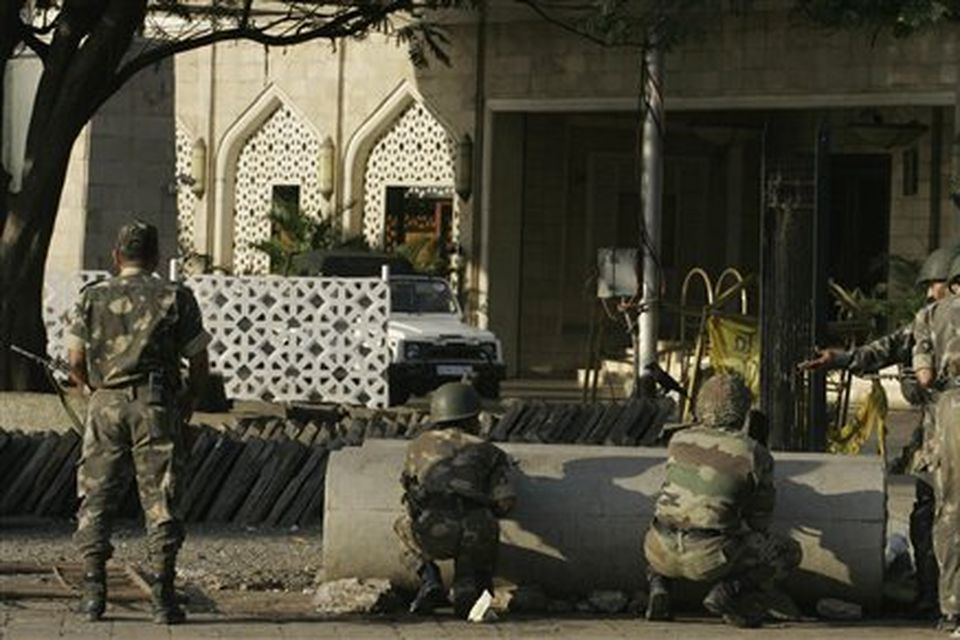Indian Army personnel take positions outside the Taj Hotel in Mumbai, India, Thursday, Nov. 27, 2008. Teams of gunmen stormed luxury hotels, a popular restaurant, hospitals and a crowded train station in coordinated attacks across India's financial capital, killing at least 101 people, taking Westerners hostage and leaving parts of the city under siege Thursday, police said. A group of suspected Muslim militants claimed responsibility. (AP Photo/Rajanish Kakade)