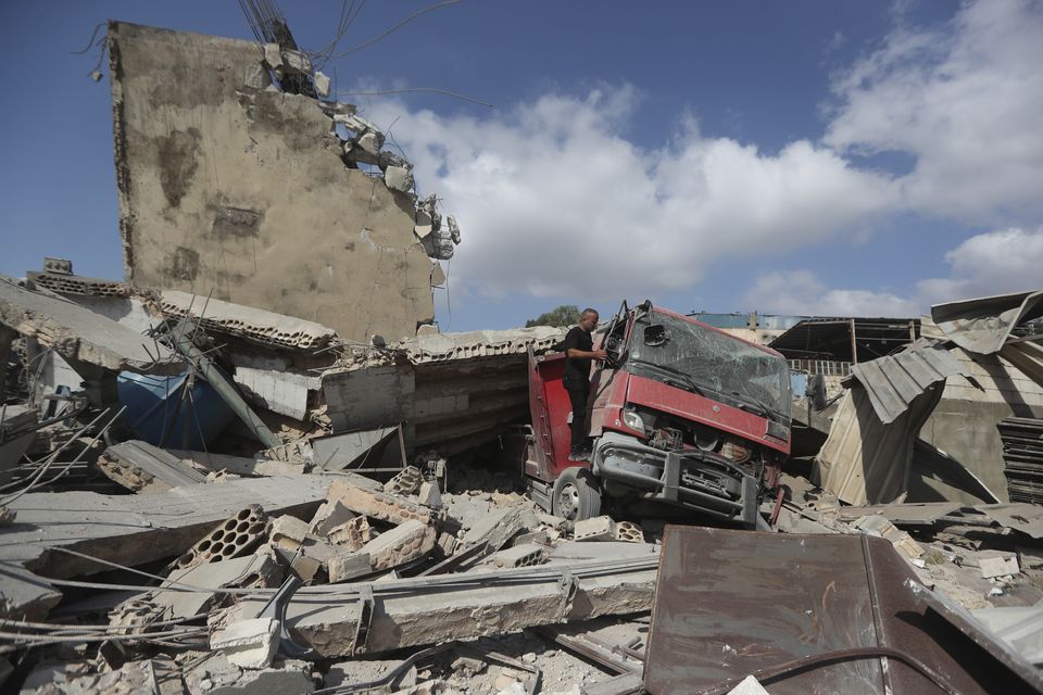 A man checks a damaged truck at an industrial area destroyed by an Israeli air strike, in Wadi al-Kfour (AP Photo/Mohammed Zaatari)