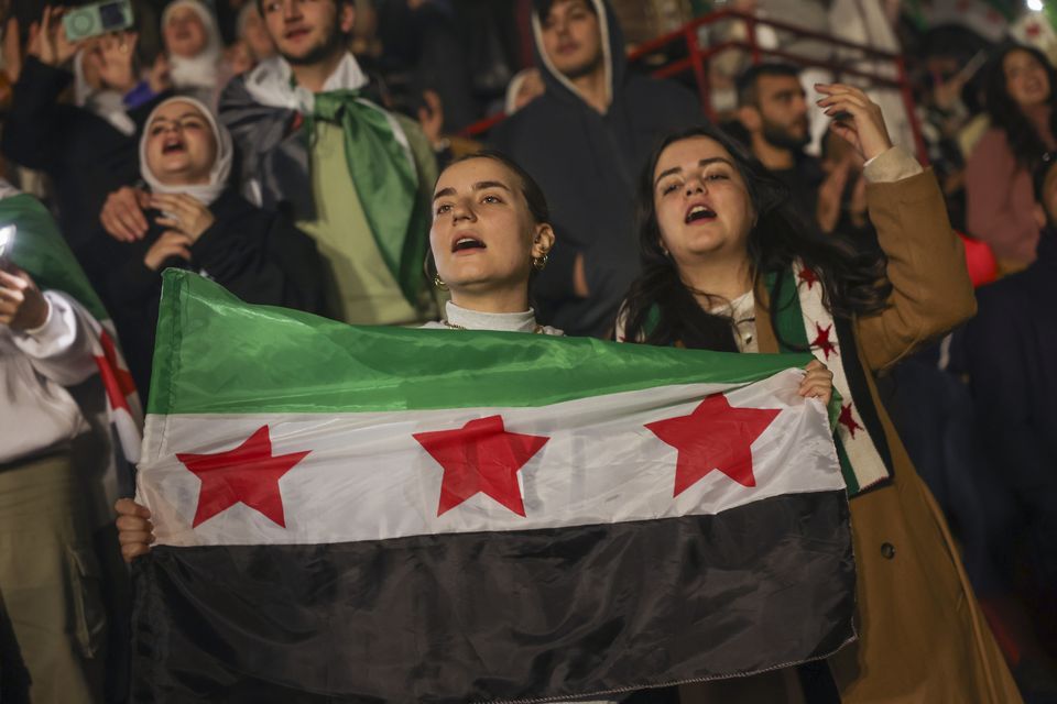 Young people wave flags at the concert (Ghaith Alsayed/AP)