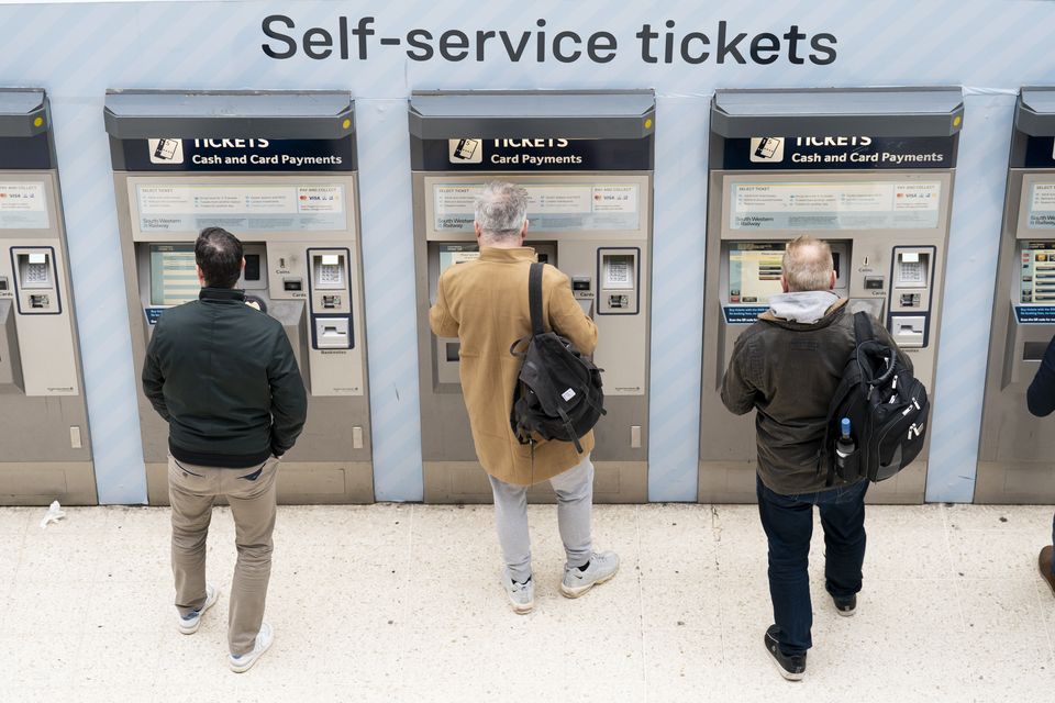 People use a ticket machine at Waterloo train station in London (Kirsty O’Connor/PA)