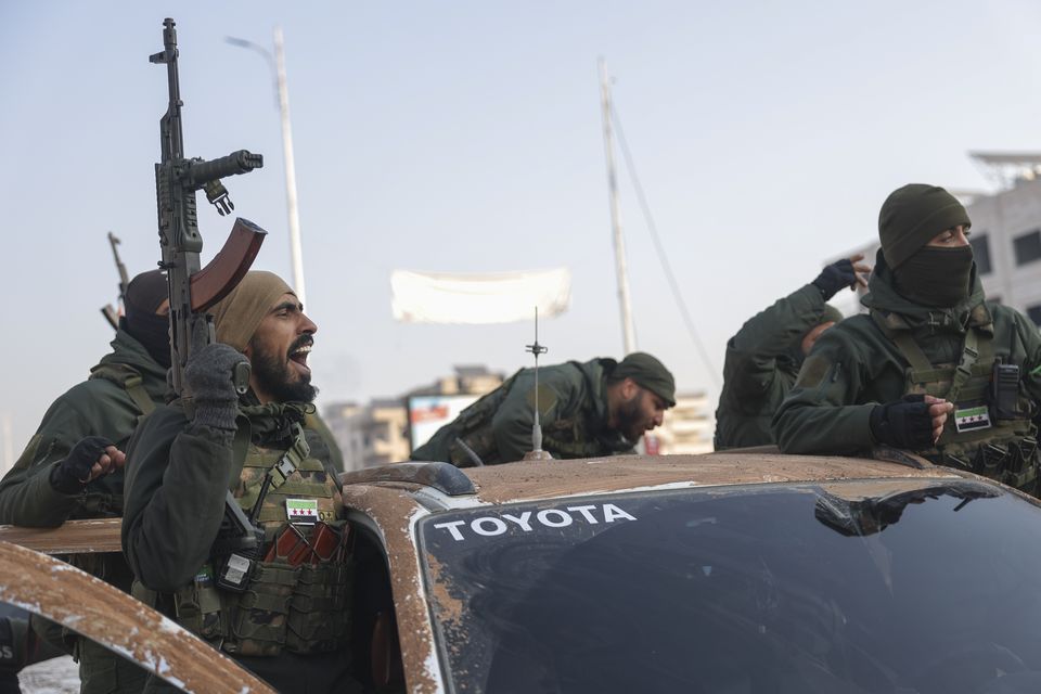 Syrian opposition fighters ride along the streets in the aftermath of the opposition’s takeover of Hama (AP Photo/Ghaith Alsayed)