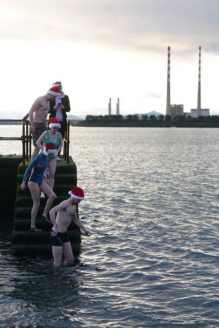 People take part in the Clontarf Yacht and Boat Club annual charity Christmas swim in Dublin in aid of the RNLI (Brian Lawless/PA)