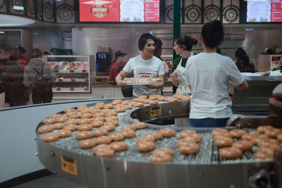 PARIS, FRANCE - DECEMBER 23: Confectionery workers at the store Krispy Kreme on December 23, 2023 in Paris, France. The American food chain specialising in donuts has just opened its very first store in the heart of Paris, launching the advertising campaign "Macaron Resignation". A first step for the chain, set to expand throughout France with the opening of further points of sale in 2024. (Photo by Ameer Alhalbi/Getty Images)