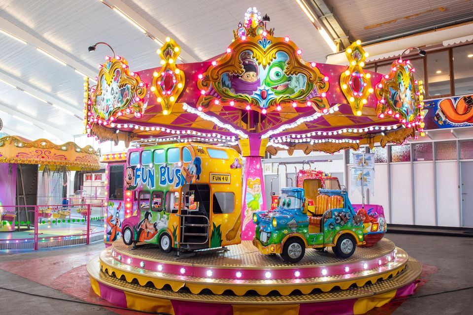 The colourful rides and attractions of Curry's Fun Park, formerly Barry's Amusements, glowing at dusk in Portrush.