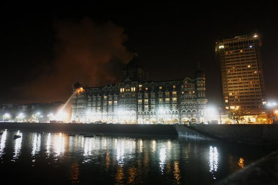 Fire engulfs a part of the Taj Mahal Hotel as firemen try to douse it in Mumbai, India, Wednesday, Nov. 26, 2008. Teams of heavily armed gunmen stormed luxury hotels, a popular restaurant, hospitals and a crowded train station in coordinated attacks across India's financial capital Wednesday night, killing at least 78 people and taking Westerners hostage, police said. A previously unknown group, apparently Muslim militants, took responsibility for the attacks.   (AP Photo/Gautam Singh)