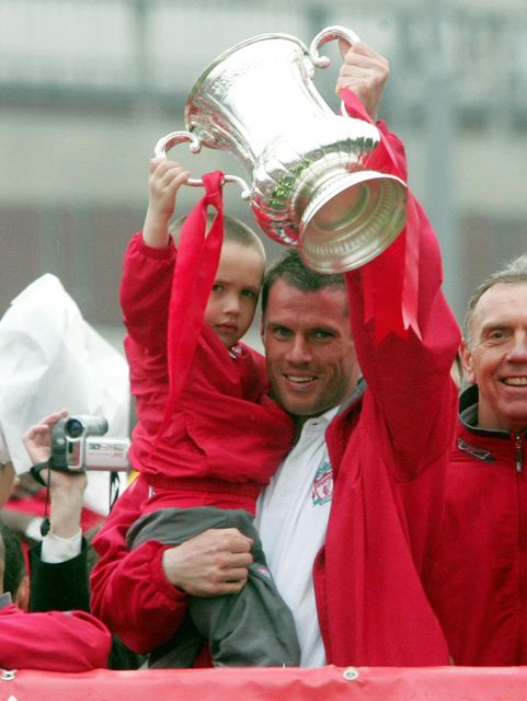 James Carragher holds the FA Cup with father Jamie after Liverpool won the FA Cup in 2006 (Martin Rickett/PA)