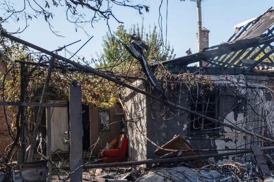 A damaged private house in the background of fragments of a shot down Russian military plane (Iryna Rybakova via AP)