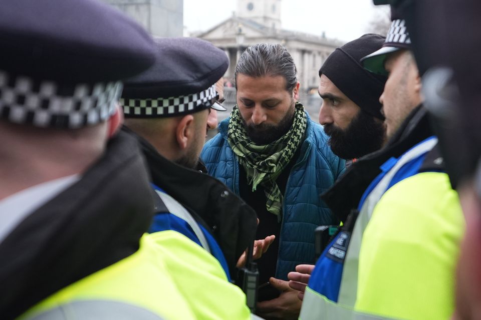 Police speak to a man (James Manning/PA)