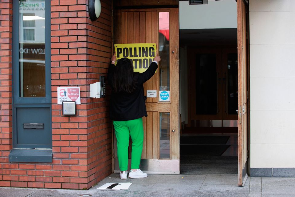 贝尔法斯特南部 Agape 中心投票站团队的一名成员在 2024 年大选投票站开放前悬挂标牌。Liam McBurney/PA Wire