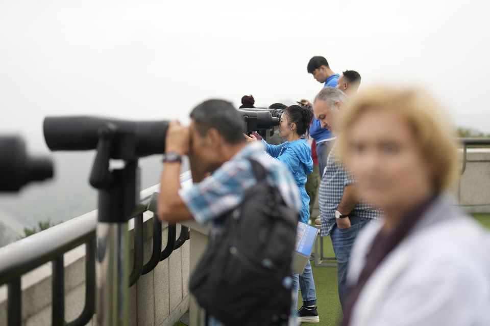 Visitors use binoculars to see the North Korean side from the unification observatory in Paju, South Korea (Lee Jin-man/AP)