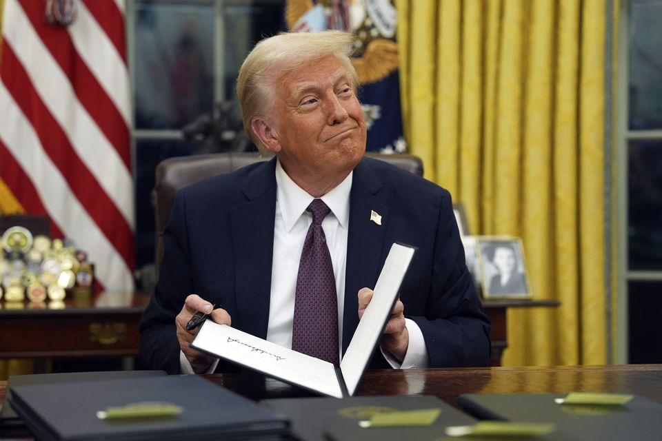 President Donald Trump signs executive orders in the Oval Office of the White House on Monday (Evan Vucci/AP)