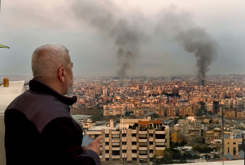 A man watches smoke rising over Beirut after Israeli air strikes (Hussein Malla/AP)