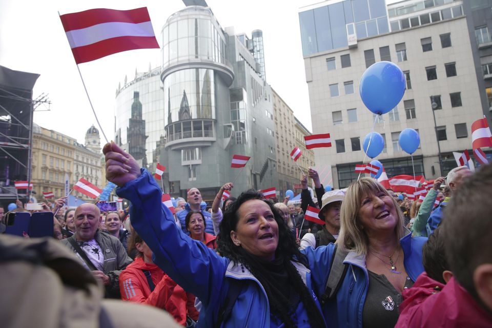 Supporters wave Austrian flags during the final election campaign event of the Freedom Party (Heinz-Peter Bader/AP)