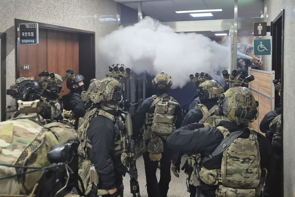 National Assembly employees spray a fire extinguisher towards soldiers at the National Assembly in Seoul (Cho Da-un/Yonhap via AP)