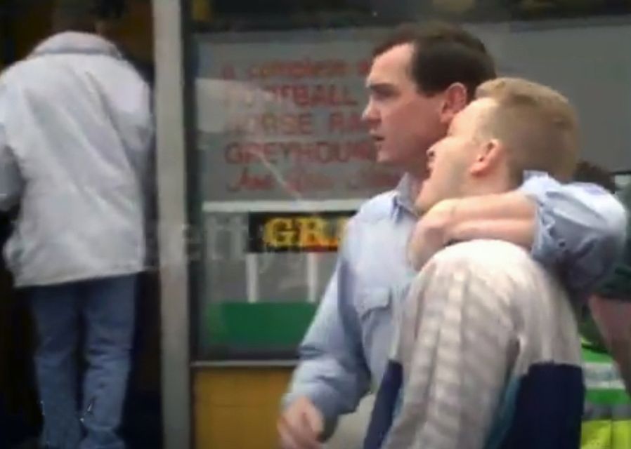 Billy pictured outside the bookies(blue and white ) on the day of Massacre having just received the news of his father's murder.