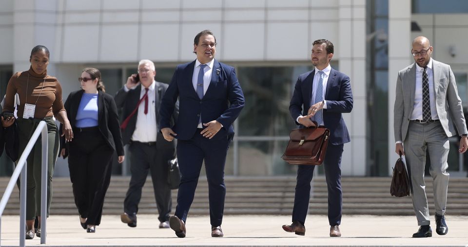 George Santos, centre, leaves court following a hearing in his fraud trial (James Carbone/AP)