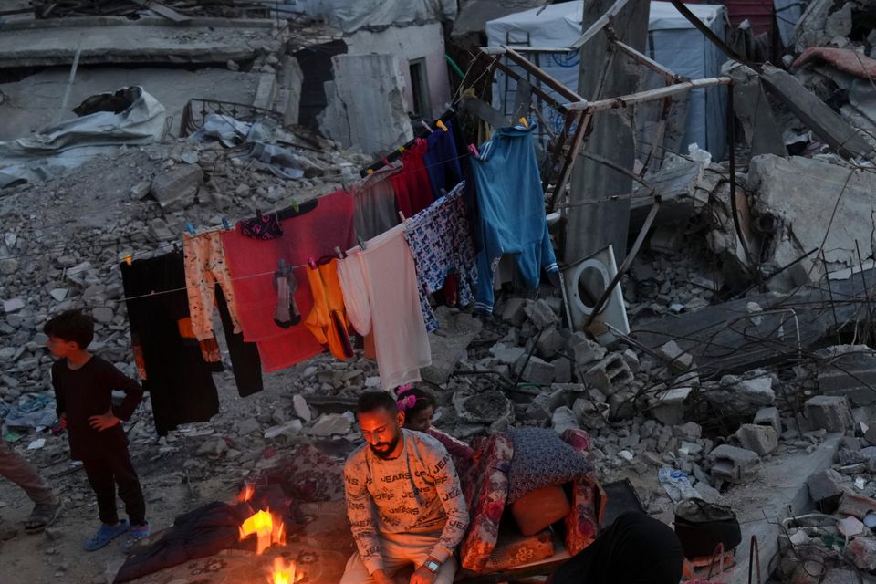 Members of Palestinian Marouf family cook outside their destroyed house by the Israeli army’s air and ground offensive in Jabaliya, Gaza Strip (Jehad Alshrafi/AP)