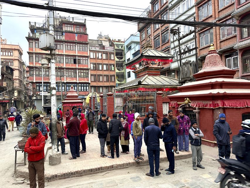 Nepalese people stand after rushing out of their homes after experiencing an earthquake in Kathmandu, Nepal, (Sunil Sharma/AP)